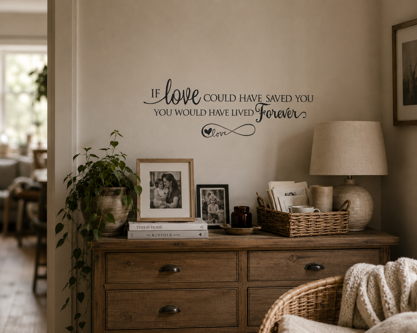 Black memorial quote wall decal reading “If Love Could Have Saved You You Would Have Lived Forever” displayed above rustic timber drawers in a warm neutral styled home interior.