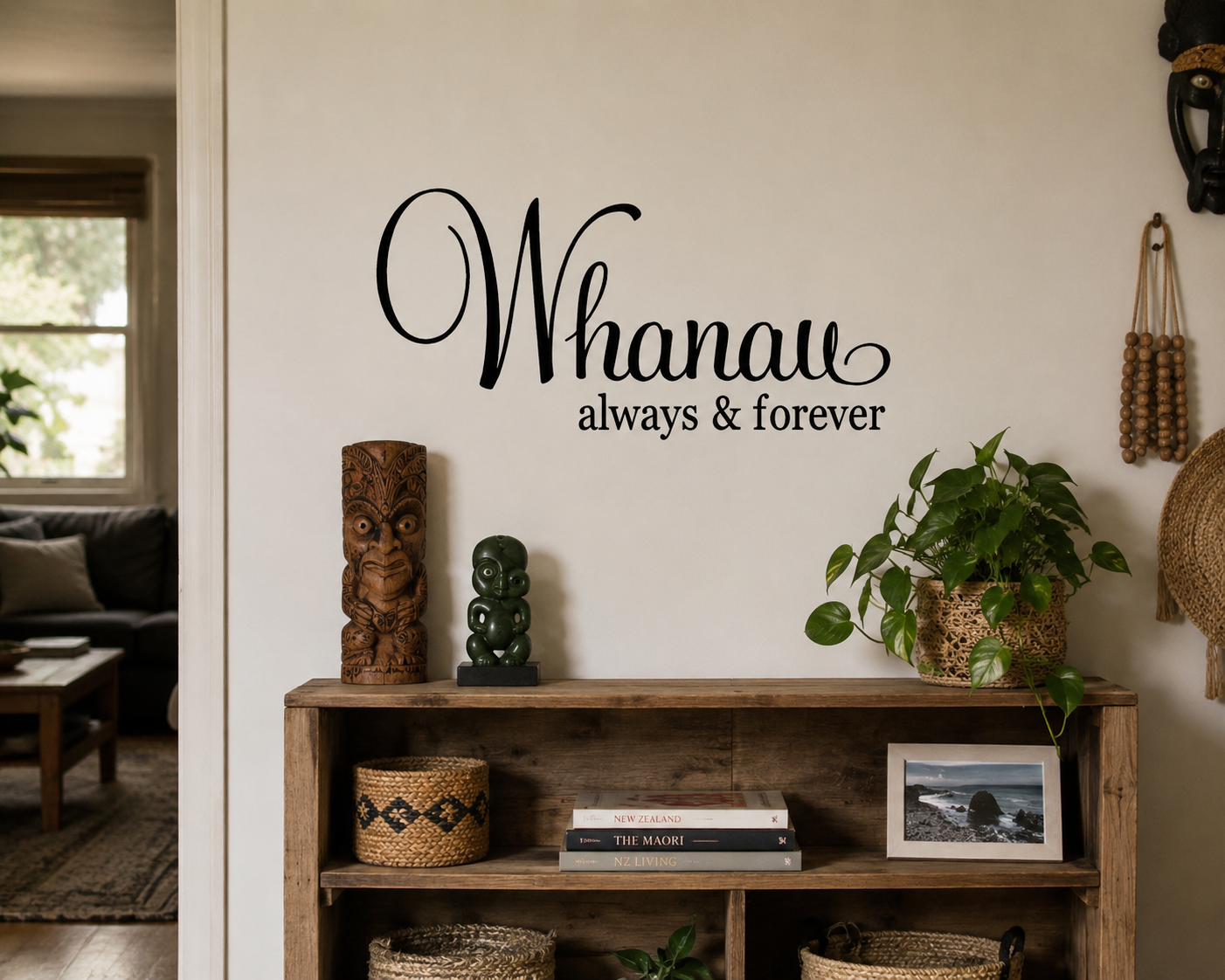 Whānau Always & Forever removable black vinyl wall decal displayed above a wooden shelf in a warm relaxed family living room.