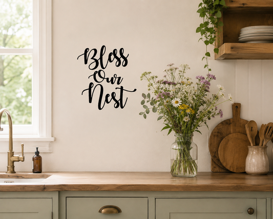 Bless Our Nest removable wall decal displayed on a kitchen wall beside a bench top with a vase of wild flowers and farmhouse décor.