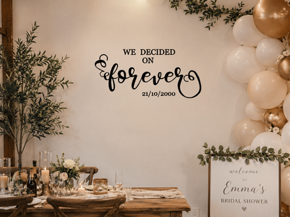 Wedding-themed decor with balloons, flowers, and a sign on a wall.