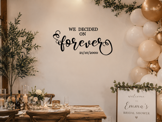 Wedding-themed decor with balloons, flowers, and a sign on a wall.