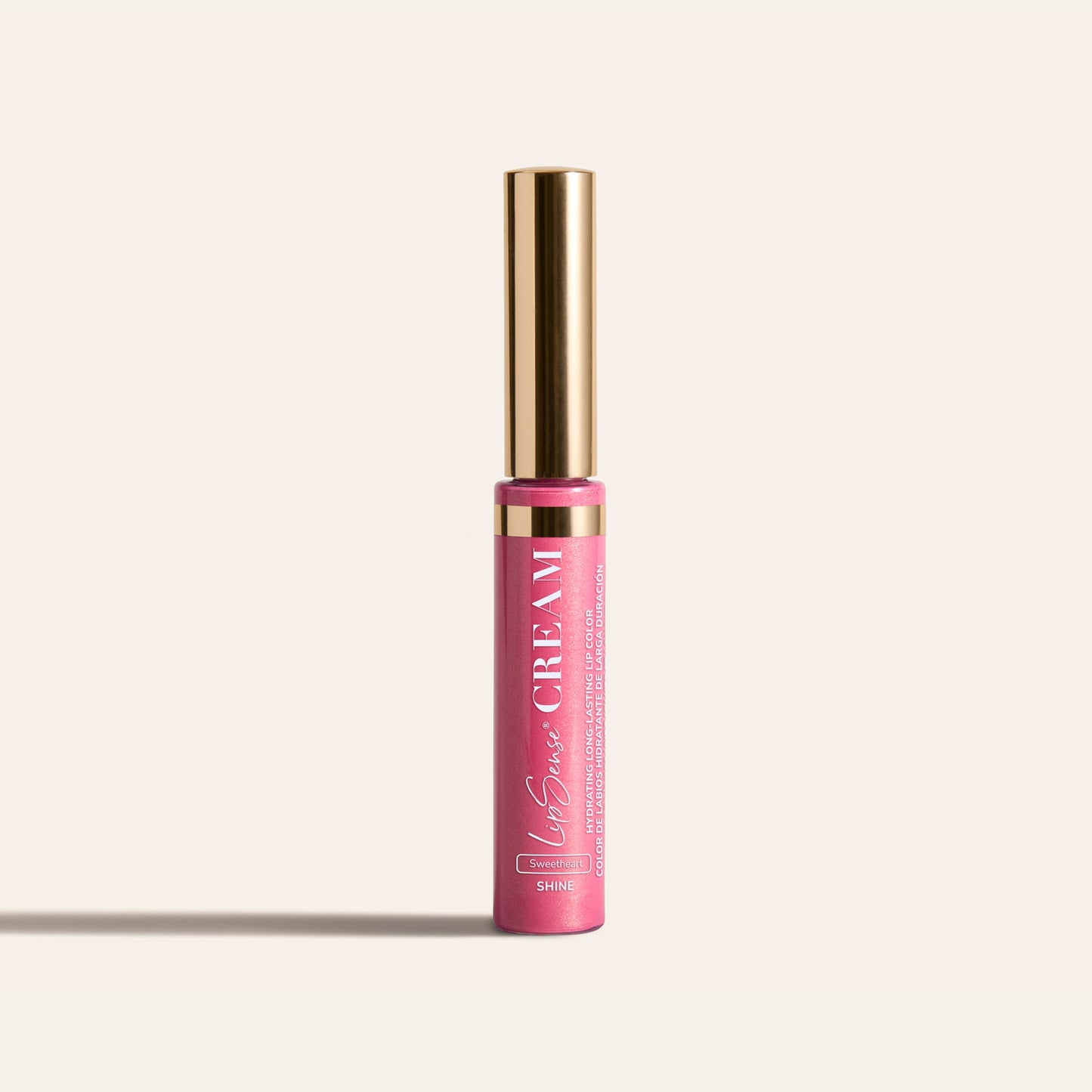 LipSense HydraMatte pink lip color bottle with a tall gold cap on a light beige background