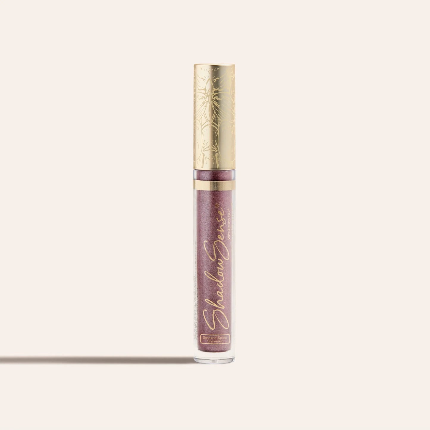 ShadowSense Eyeshadow NZL in a tall clear tube with purple glittery formula and an ornate gold cap