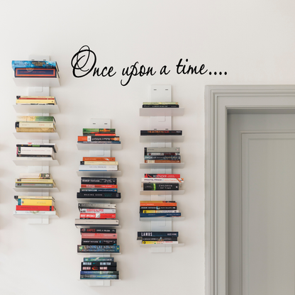 Wall with vertical bookshelves filled with books and a decorative text 'Once upon a time...' above.
