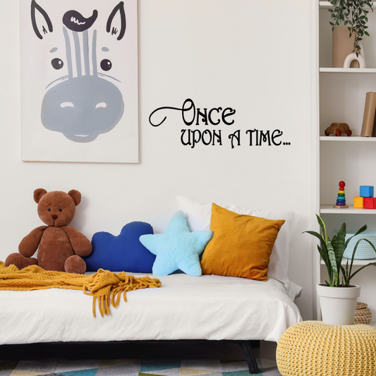 Children's bedroom with a bed, teddy bear, and decorative pillows, featuring a 'Once Upon a Time' wall decal. Two Little Giggles Wall Decal