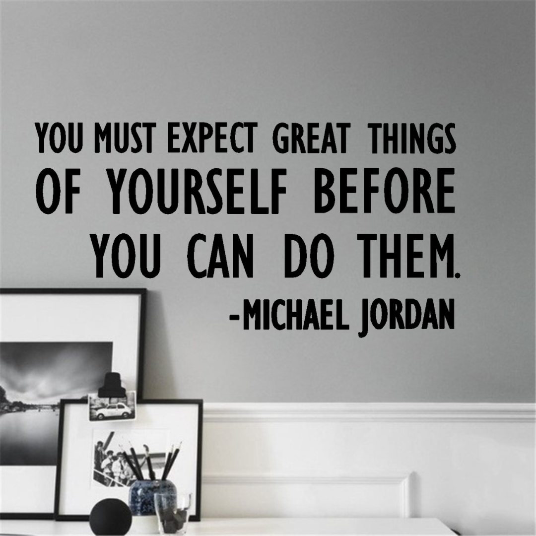 Wall decal with a motivational quote by Michael Jordan on a gray wall. Two Little Giggles Wall Decals