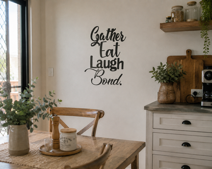 Black Gather Eat Laugh Bond kitchen wall decal displayed in a relaxed neutral kitchen dining space with wooden furniture, warm lighting and natural home styling.