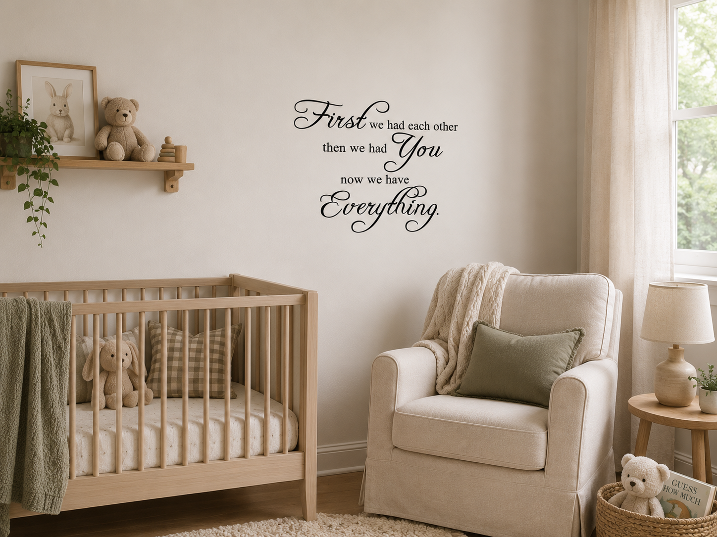 Black removable vinyl wall decal reading “First we had each other then we had you now we have everything” displayed above a wooden cot in a calm neutral nursery.