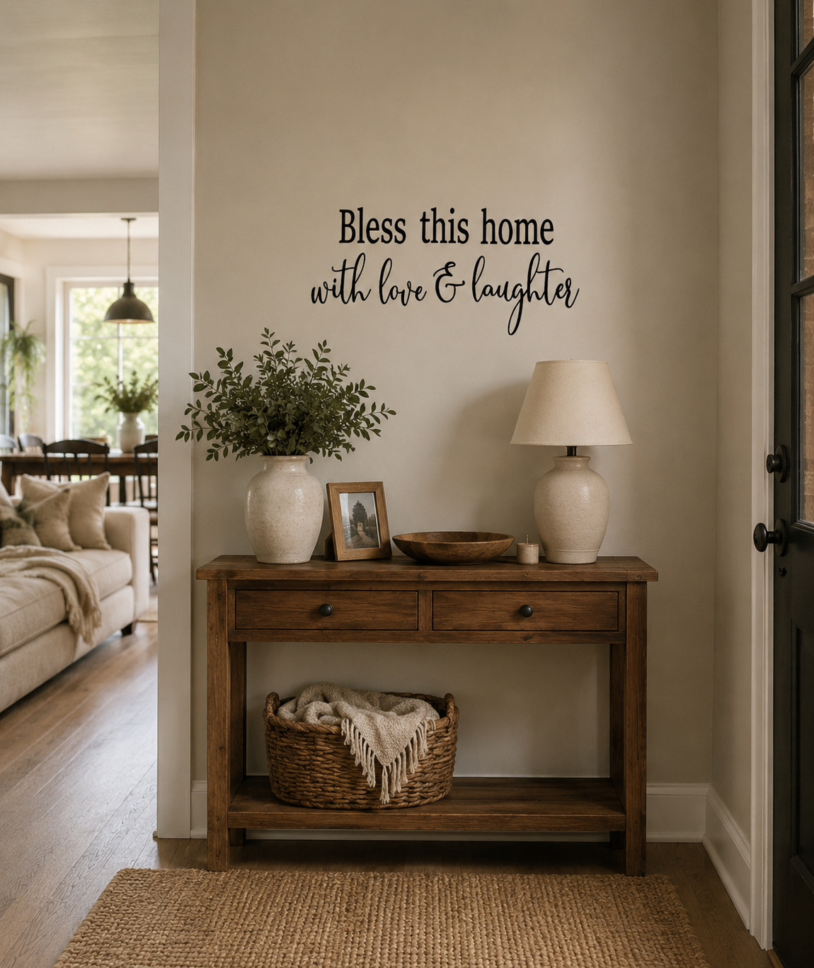 “Bless This Home” removable black vinyl wall decal displayed in a cozy country-style hallway with warm farmhouse décor and open-plan living background.